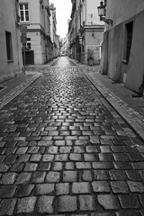 Cobblestone street and historic tenement houses after rain in the city of Poznan
