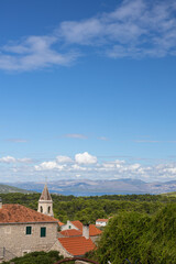 Fototapeta premium Scenic Coastal Village With Stone Houses, Red Roofs and Church Steeple Overlooking the Sea