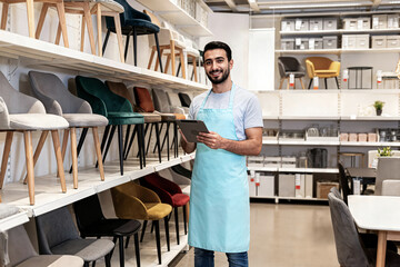 shopkeeper man concept apron using tablet while standing furniture store concepto de dependiente con delantal utilizando una tableta mientras está de pie en una tienda muebles concept d'un commerçant
