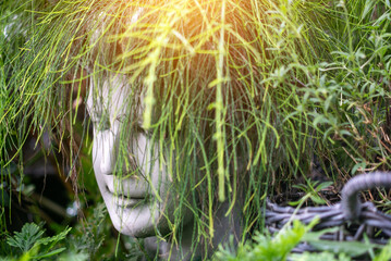 Unique Head Sculpture Surrounded by Plants
