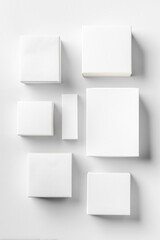 Various white boxes of different sizes arranged on a clean surface, showcasing minimalistic design and ample copy space for branding or text