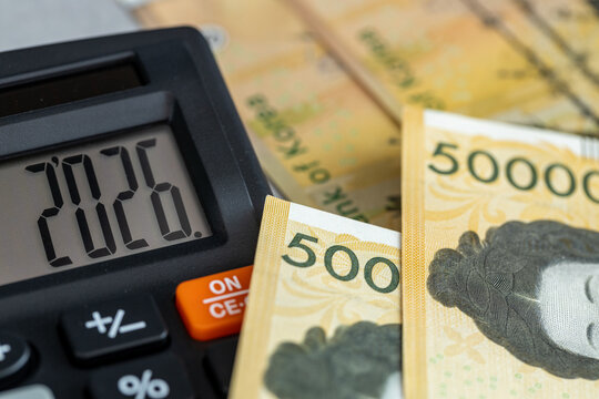 South Korea money. Finance 2026. Business and economic concept. Symbol of the Korean currency, won. The year 2026 displayed on a calculator. Financial background. Close up