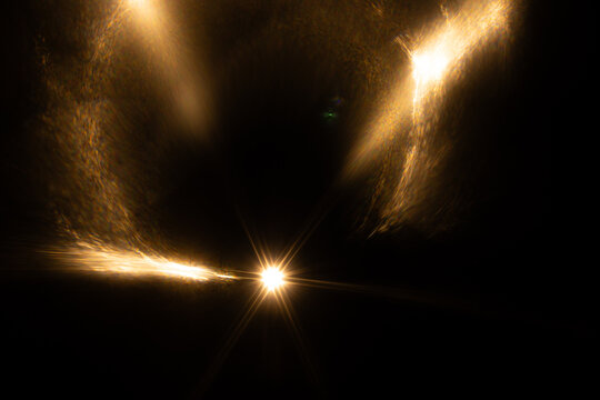 Lens Flare. Light over black background. Easy to add overlay or screen filter over photos. Abstract sun burst with digital lens flare background. Gleams rounded and hexagonal shapes, rainbow halo.