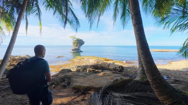 Tourist taking photo of Punta Manzanillo rock formation at the beach, Costa Rica