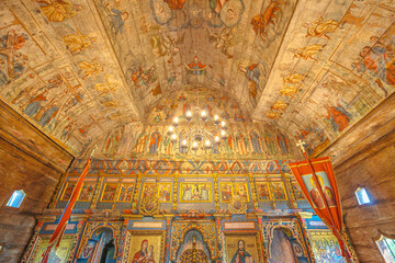 Maramures, Romania - Aug 13, 2025: 18th-century wooden Church of the Archangels Michael and Gabriel in Plopis, Sisesti, Maramures, Romania, with vivid frescoed ceiling and biblical iconography