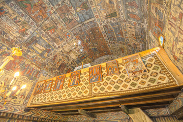 Maramures, Romania - Aug 13, 2025: Interior of a traditional Romanian wooden church in Desesti, Maramures. Elaborate biblical scenes cover the painted ceiling
