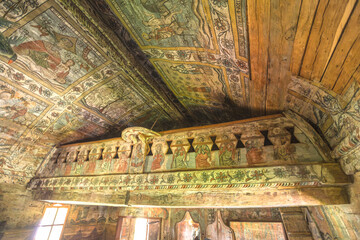 Maramures, Rogoz, Romania - Aug 13, 2025: Rogoz Holy Archangels Church interior showing intricate religious frescoes on the wooden ceiling and balcony, representing historical Orthodox art