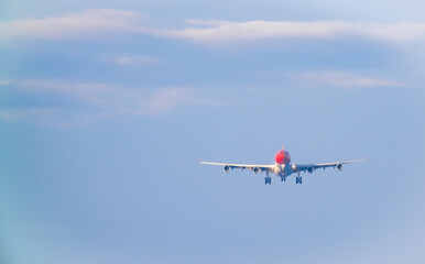 The plane lands over the sea at Phuket airport. A passenger plane lands on Mai Khao Beach, a popular tourist attraction.