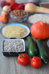 Assortment of various healthy fruits, vegetables, grains and legumes. Selective focus, wooden background.