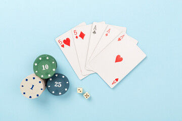 Poker chips and playing cards on color background, top view. Casino card game
