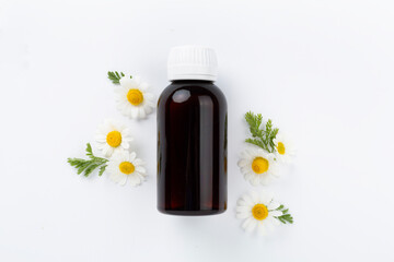 Fresh chamomiles with medicines on color background, top view