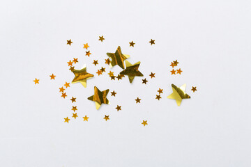 Golden star shape confetti on color background, top view