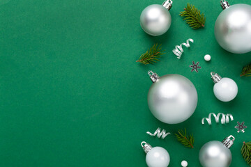 Grey Christmas balls with decor on color background, top view