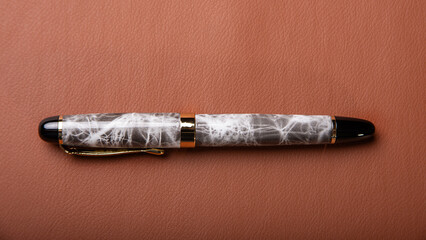 Fountain pen, beautiful fountain pen in detail on leather surface, selective focus.