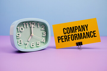 Company Performance text and alarm clock on blue and purple background
