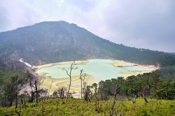 view of white crater with sulfuric gas in java in indonesia