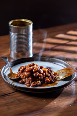 A can of chilly and a plate with chilly beans on it ready to be devoured