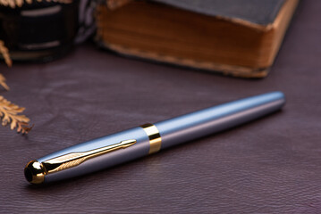 Fountain pen, beautiful fountain pen in detail on leather surface, selective focus.
