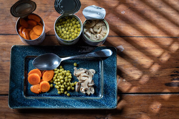 Servings of canned vegetables on a plate as a concept for National Canned Food Day.