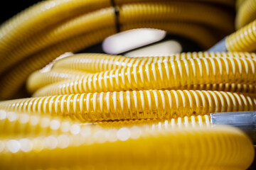 Close-up view of coiled yellow corrugated plastic hoses showing flexible tubing texture used in gas line installation, industrial piping and construction systems