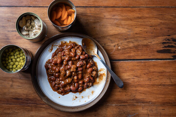 Servings of chilly and canned vegetables on a plate as a concept for National Canned Food Day.