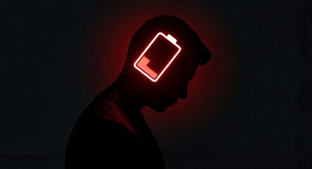 A silhouette with a glowing red low battery icon on a dark background, great for mental health awareness, burnout prevention content, and digital wellness campaigns.