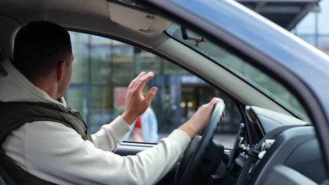 Male sitting in car waiting for daughter looking in window. Rear of male sit in vehicle waits for his kid from school. Man pick up his daughter. Teenage girl running crossing the street