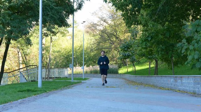 Guy feeling pain after working out. Handsome man jogging outside
