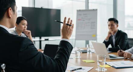 People in a business meeting with a whiteboard and a large screen.
