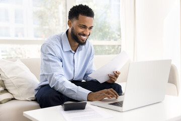 Happy African guy feels satisfied while planning budget