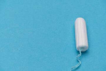 White tampon on a blue background, product close-up shot