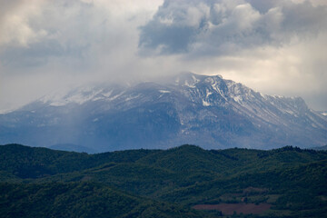 Scenic natural landscape with mountains, forest, and open terrain captured in soft light. Peaceful outdoor setting ideal for travel, nature, and environmental themes.