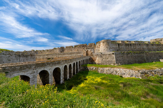 Greece, Peloponnese, Methoni - 4 April 2024 - The historic bridge to reach the Venetian fortress of Methoni, surrounded by greenery and flowers