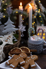 There are gingerbread men on the plate. A decorated Christmas tree and festive ornaments are in the background.