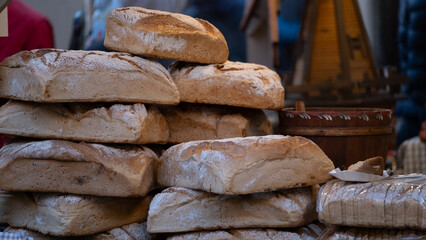 Freshly baked loaves of bread stacked at market stall