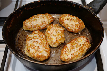 Meat cutlets are fried in a pan. Five cutlets are cooking. Cooking, frying meat