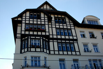 A building with a timber-frame facade and windows with flower boxes.