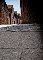 A narrow cobblestone street between old buildings.