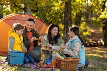 Family enjoys picnic in sunny park in autumn