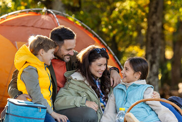 Family enjoys picnic in sunny park in autumn