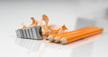 Sharpening pencils. Yellow wooden graphite pencils with erasers, pencil shavings