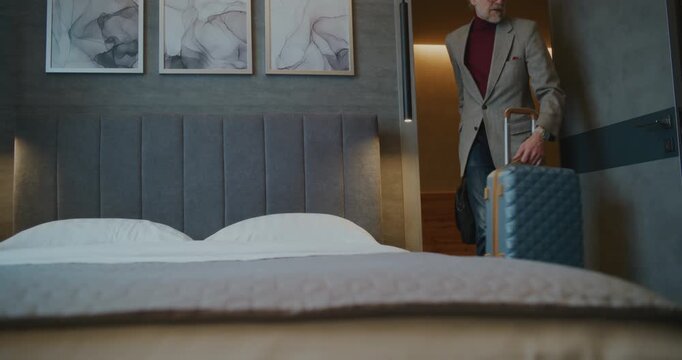 Fatigued Man Setting Down Bag Before Immediately Reaching For Smartphone Check Social Media. Concept Modern Reality Digital Habits, Quick Search For Digital Comfort in New or Familiar Space. Handheld.