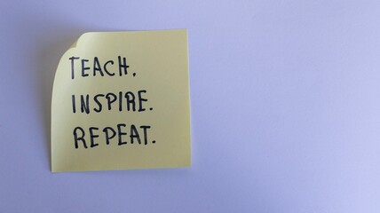 'Teach, Inspire, Repeat' Motto on Sticky Note against Wrinkled Paper Background