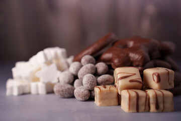 a tempting array of assorted chocolates and confections in soft focus display, featuring white, milk, and dark treats enhanced by a warm, inviting ambient light setting, delight, inviting, light