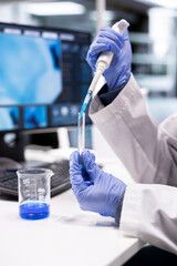 Close up of scientific expert works in laboratory with pipette and flask, preparing chemical...