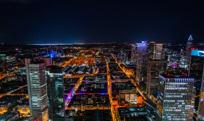 City skyline at night with illuminated skyscrapers and train station.