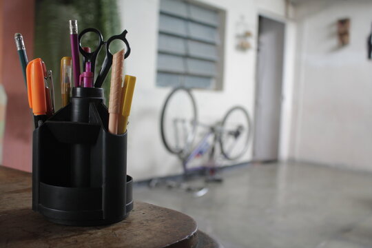 Porta l&aacute;piz color negro con una bicicleta al fondo desenfocada. 
