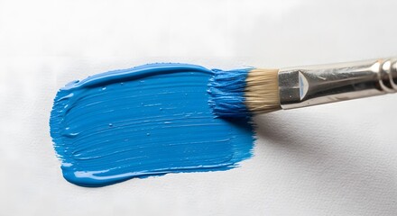 Closeup of a paintbrush with blue paint on a white background