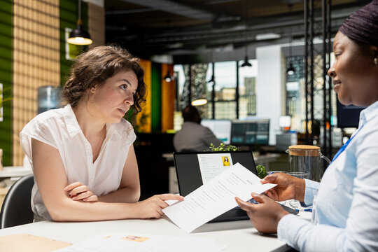Businesswoman talks about career perks in a meeting with recruiter in a corporate office, including retirement plans, medical subscription and schedule flexibility as part of hiring process.