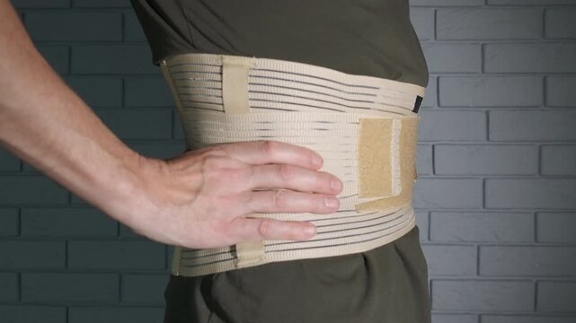Supportive corset on a lumbar spine. A view of patient with support belt on his painful back